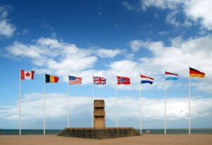 Monumento sulla spiaggia di juno beach in Normandia. Stele commemorativa e bandiere